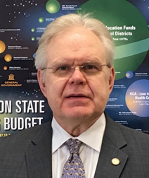 Scott Nelson standing in front of the galaxy of state government poster