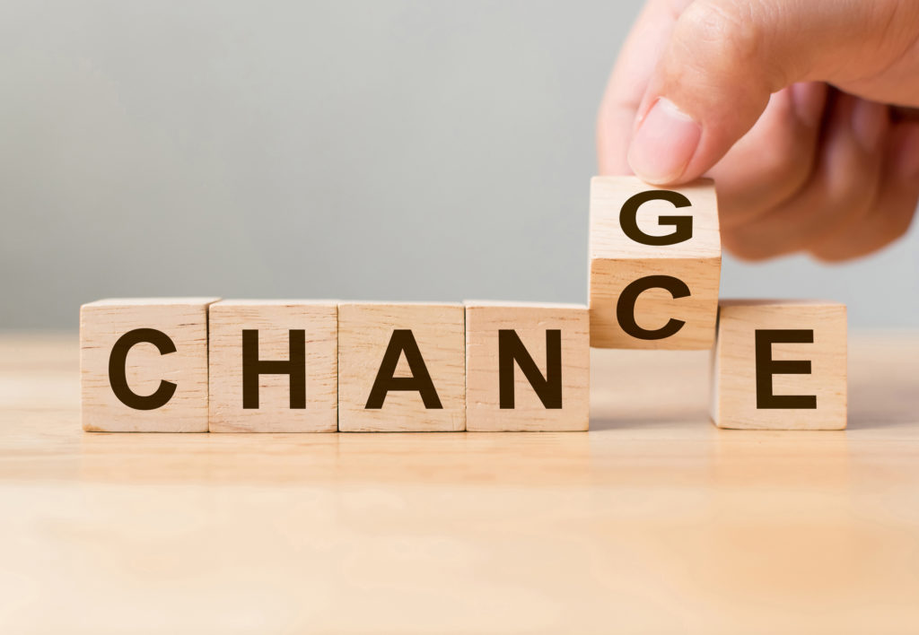 Hand flip wooden cube with word "change" to "chance"