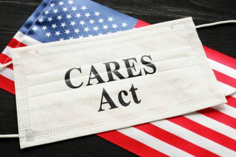American flag and mask with sign showing the phrase "CARES Act."