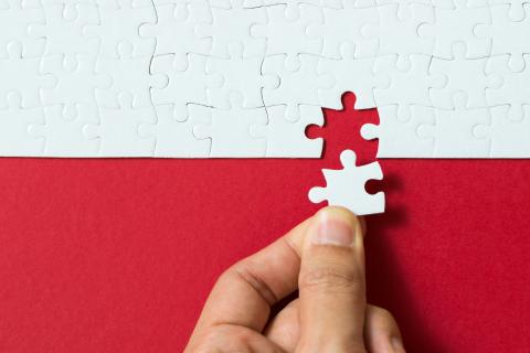 White puzzle pieces on a red background.