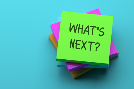 Photograph of a pad of sticky notes with the words "What's Next?" written on it.