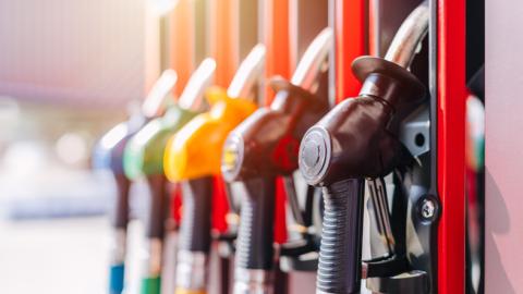 An image of a row of gas pumps in various bright colors including yellow, green, and blue.