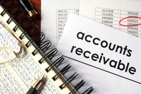 Image of a desk with a document titled "Accounts Receivable" placed next to a notepad and pen.