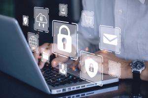 hands at computer keyboard with floating digital graphics representing cybersecurity
